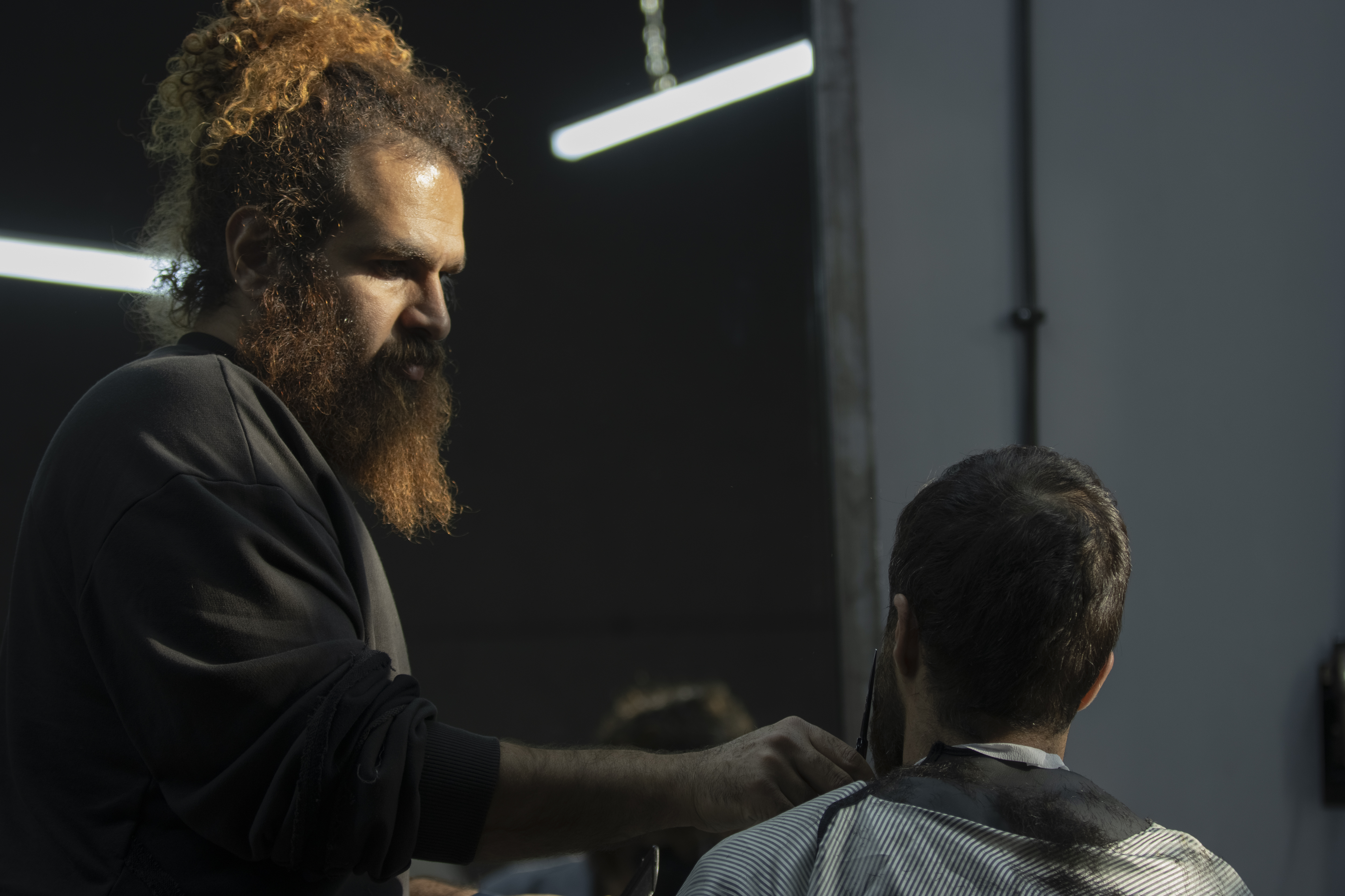 Stylist giving a precision haircut to a woman